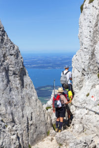 Bergsteiger am Aufstieg zum Gipfel der Kampenwand dahinter der Chiemsee, Aschau, Chiemgauer Alpen, Chiemgau, Oberbayern, Bayern, Süddeutschland, Deutschland, Europa Bergsteiger am Aufstieg zum Gipfel der Kampenwand dahinter der Chiemsee, Aschau, Chiemgauer Alpen, Chiemgau, Oberbayern, Bayern, Süddeutschland, Deutschland, Europa